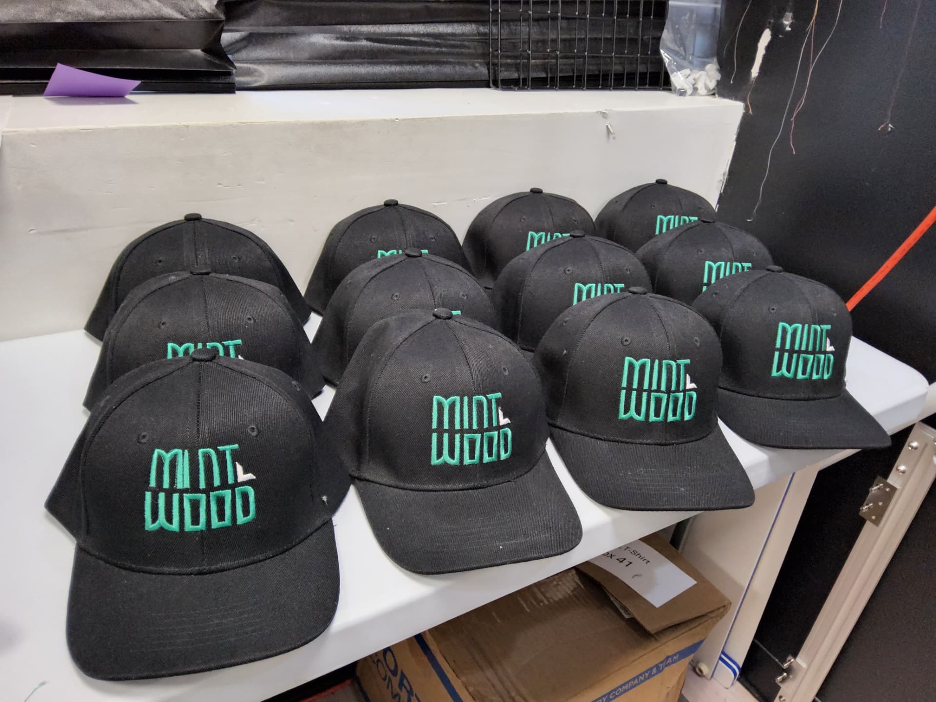 Mint Wood black caps with teal embroidered logo