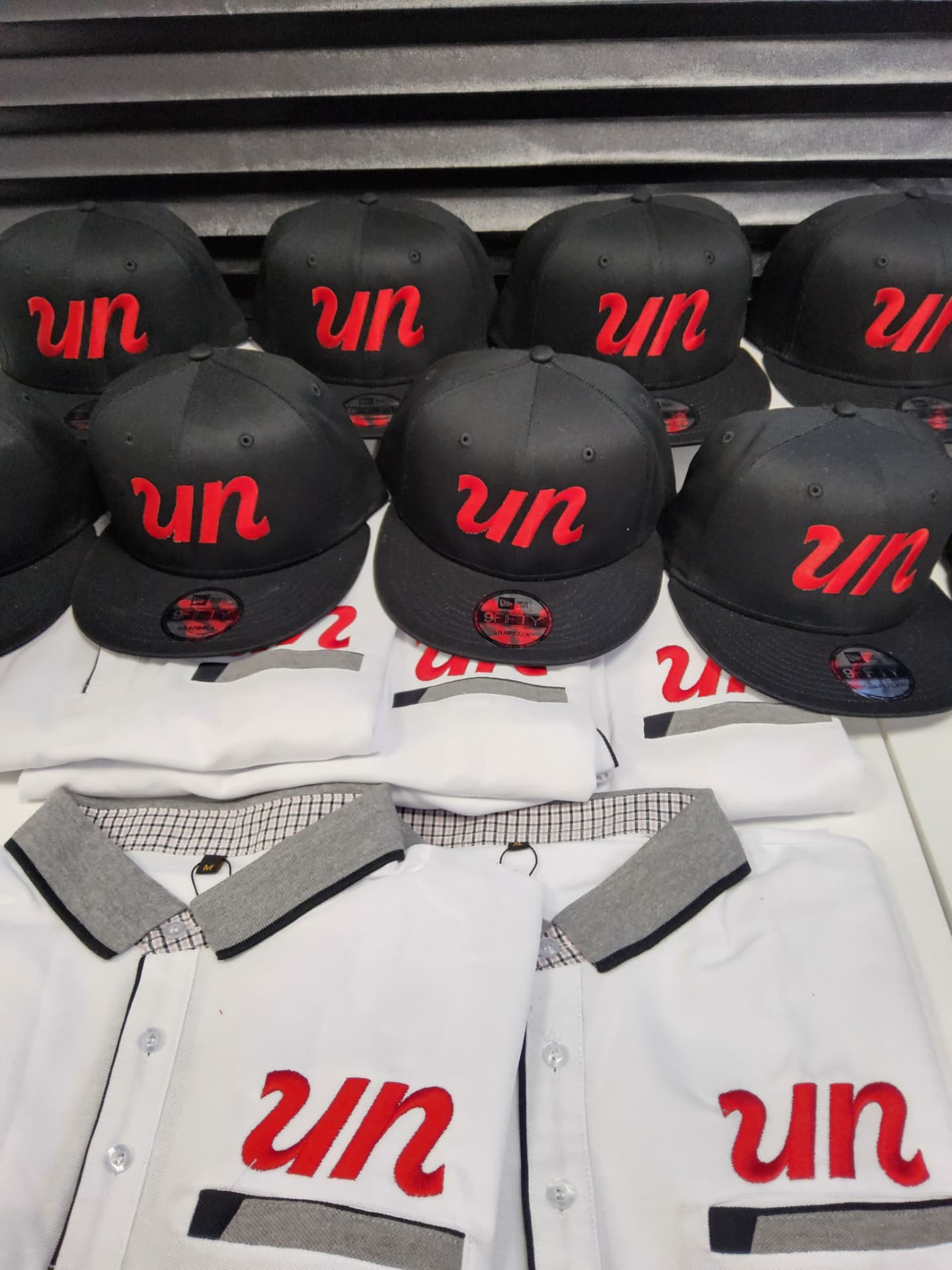 UN black snapback caps and white polos with red embroidered logo